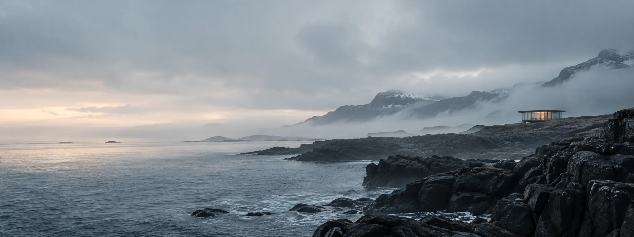 Rocky northern coast beneath a low bank of mist